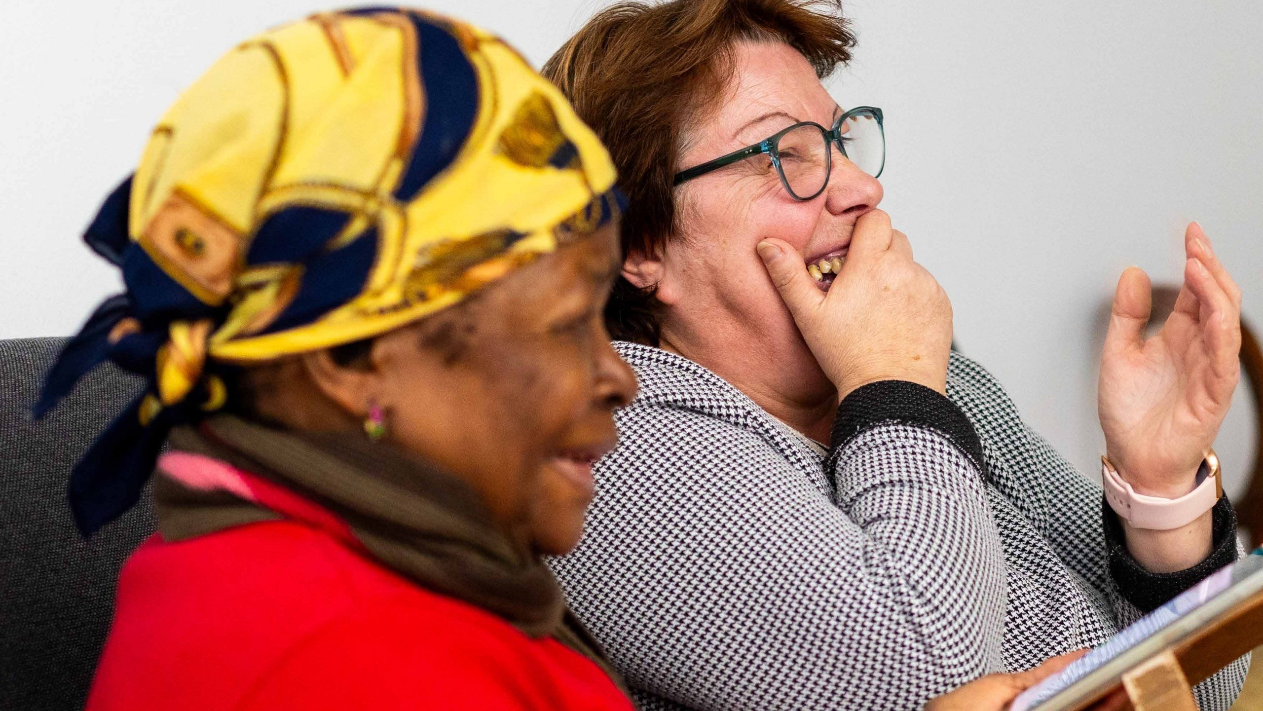 Twee vrouwen delen een vrolijk moment tijdens een ontmoeting bij Accolage