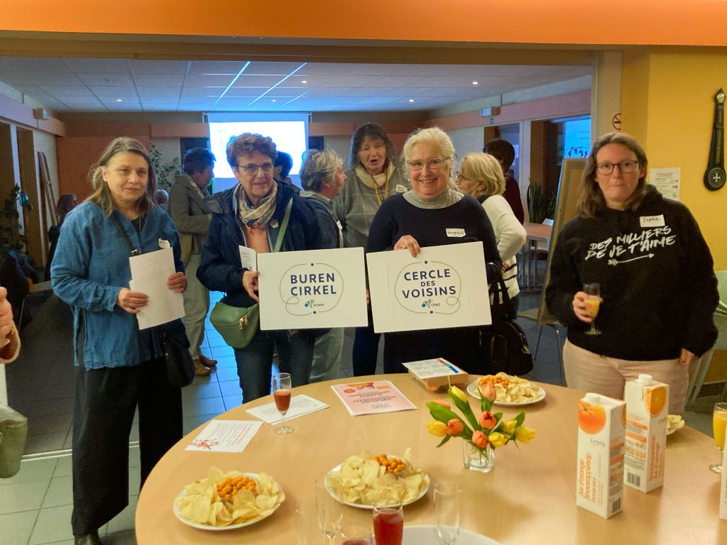 Des participantes réunies autour d’une table avec des affiches du Cercle des Voisins