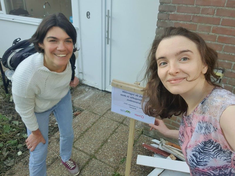 Twee medewerkers van Hoplr verspreiden uitnodigingen in de buurten van Meise