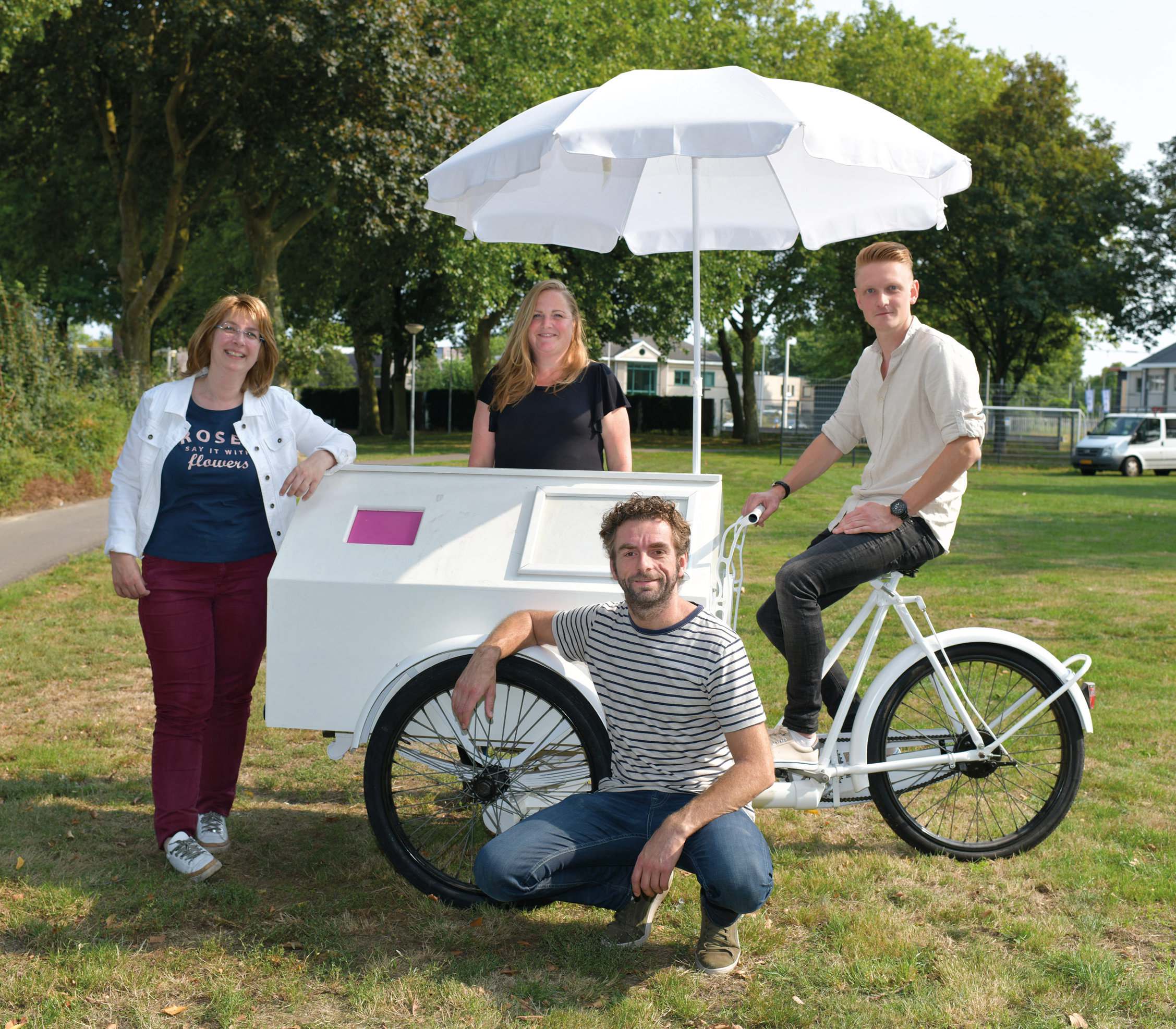Four people beside a white cargo bike with a parasol, on the cover of the Punt Welzijn case study