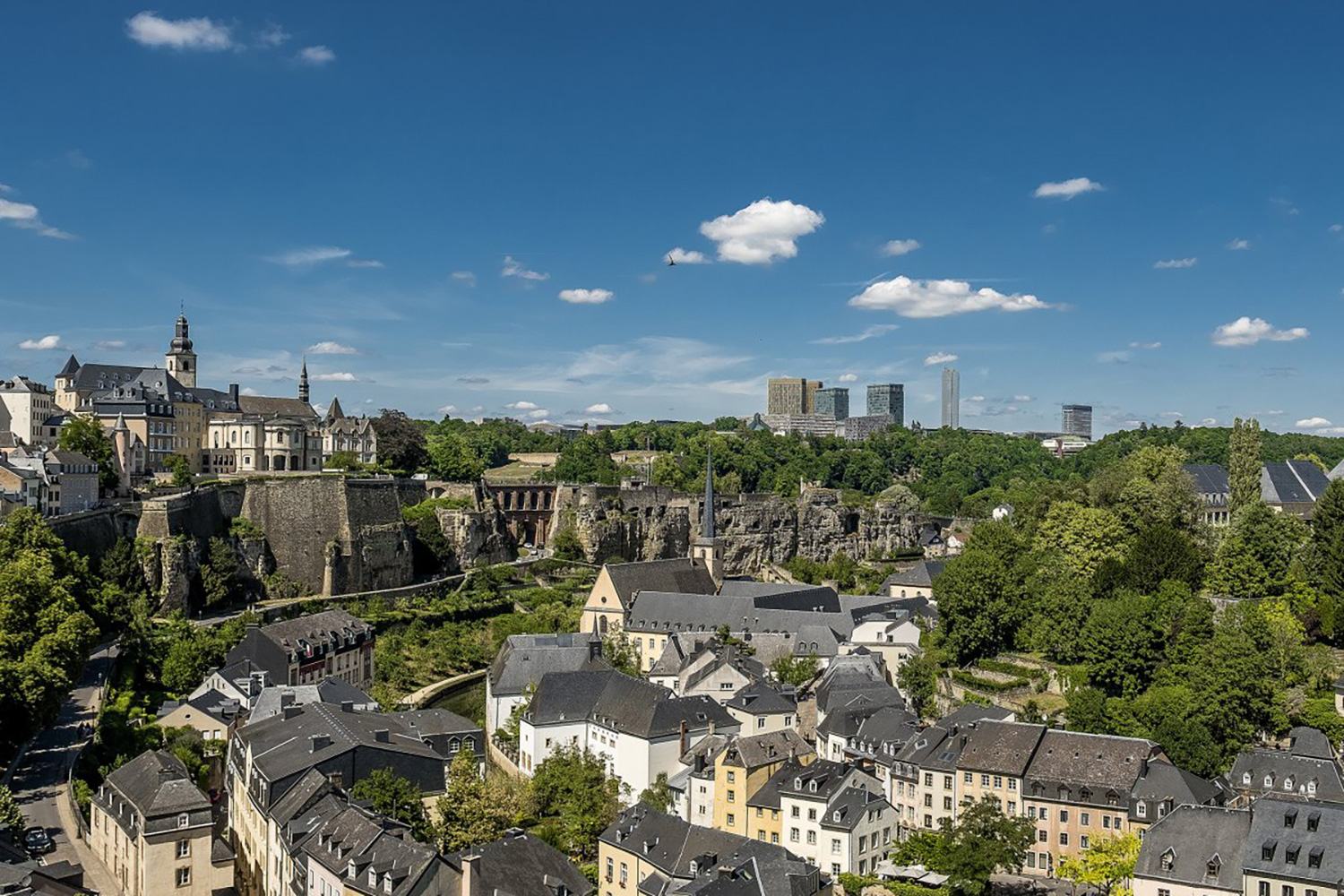 View of Luxembourg City’s historic buildings, fortifications and green valley.